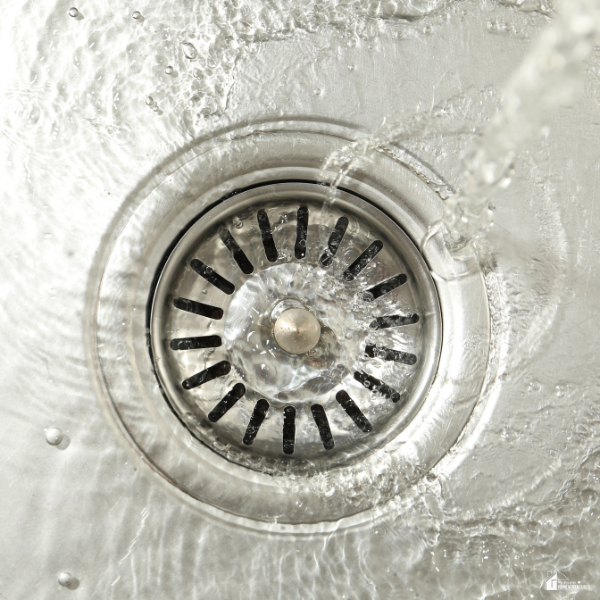 Water flows smoothly down a sink drain, representing the clear and powerful results hydro jetting delivers inside clogged pipes.