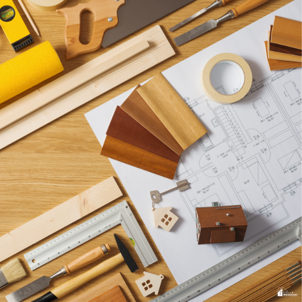 Home renovation planning workspace with tools, wood samples, and blueprints, representing careful material choices when remodeling with limited funds.