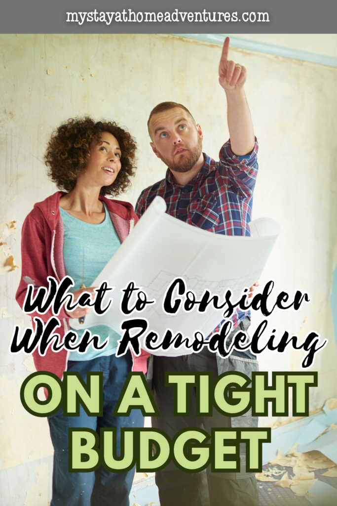 Homeowners reviewing renovation plans and inspecting walls during a remodel, representing careful planning and cost-conscious decisions before starting a budget-friendly project.