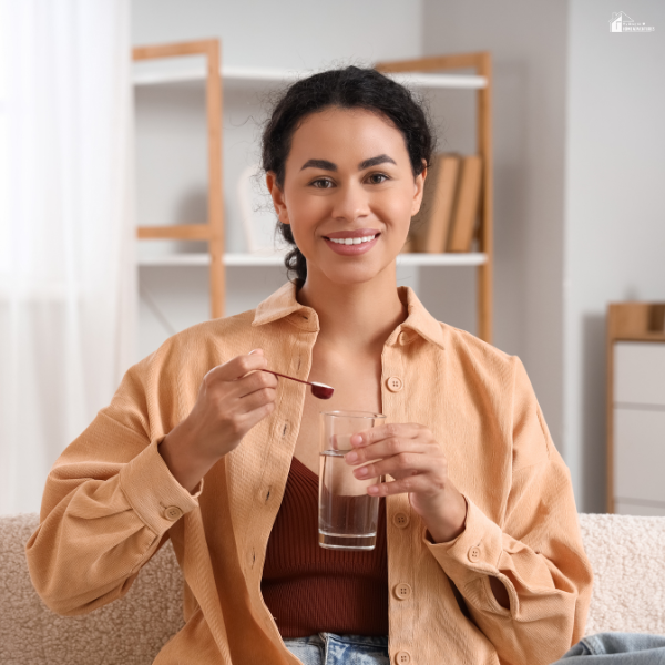 Woman at home preparing a daily wellness drink to support natural health and energy levels.