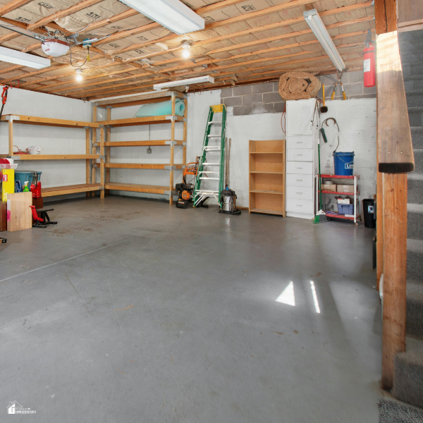 Organized garage with shelves, tools, and open floor space designed for converting into a productive home business area.