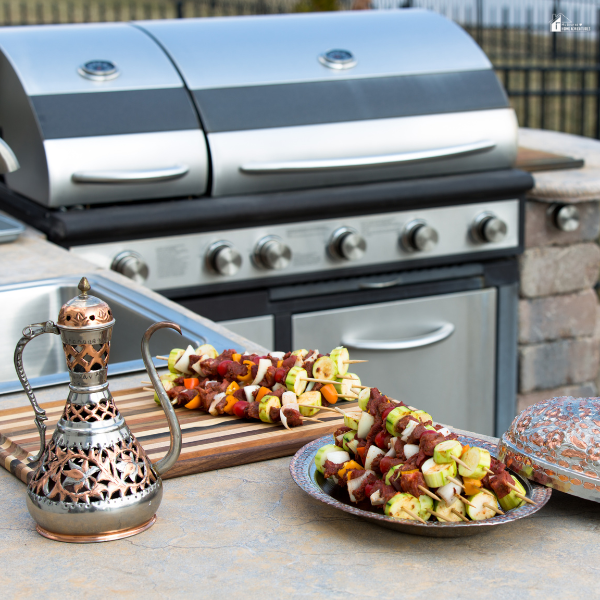Outdoor grill station with skewers and cooking tools arranged on a countertop for backyard grilling and outdoor kitchen cooking.