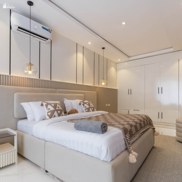 Bright modern bedroom with built-in storage, neutral decor, and wall-mounted air conditioning illustrating interior upgrades that boost home value.