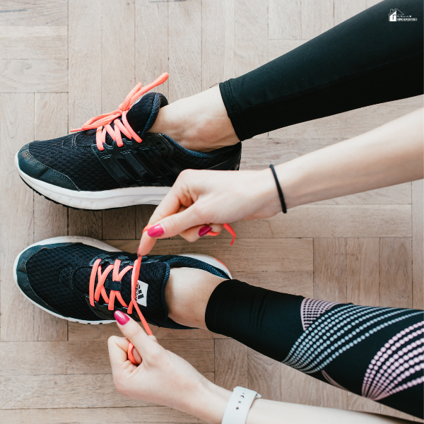 Person tying athletic shoes with bright laces, showing everyday sneakers used by busy moms for comfort and activity.