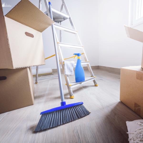 Cleaning supplies, broom, and ladder in an empty room showing preparation for detailed move-out cleaning before leaving a rental home.