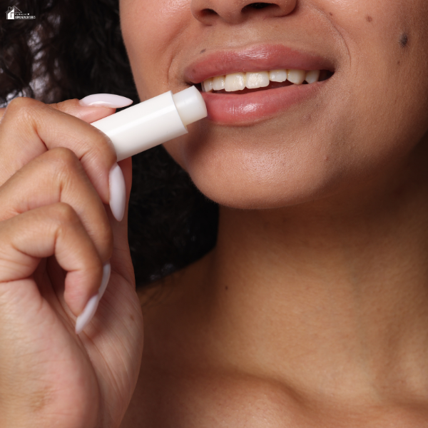 Close-up of a woman applying lip balm as a quick and budget-friendly self-care habit that fits easily into a busy mom’s daily routine.