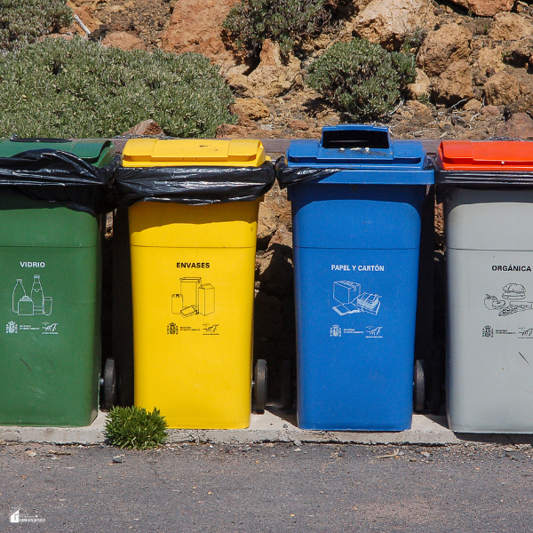 Multiple wheeled garbage and recycling bins lined up outdoors showing how mobile trash receptacles help organize household waste.