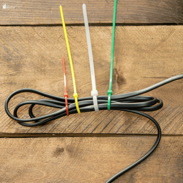 Cable neatly secured with colorful ties on a wooden surface, representing simple DIY solutions that reduce clutter and improve home organization.