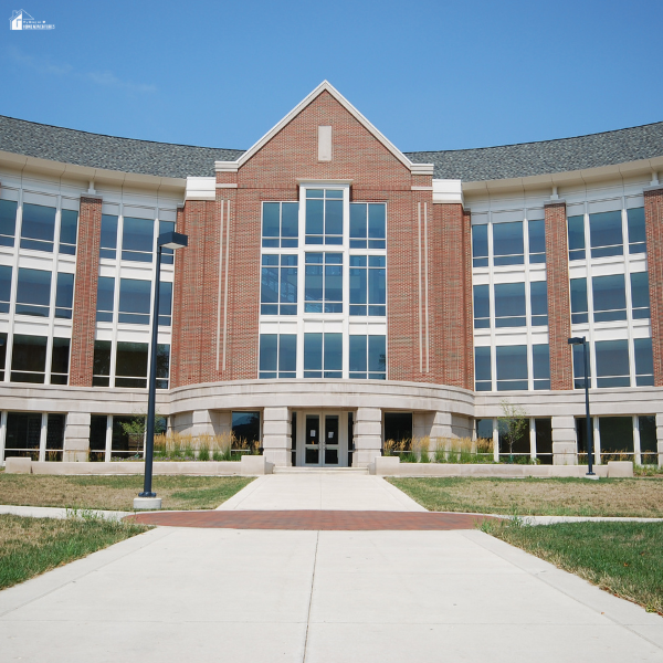 Modern college campus building with a walkway leading to the entrance, symbolizing universities where students pursue advanced learning.