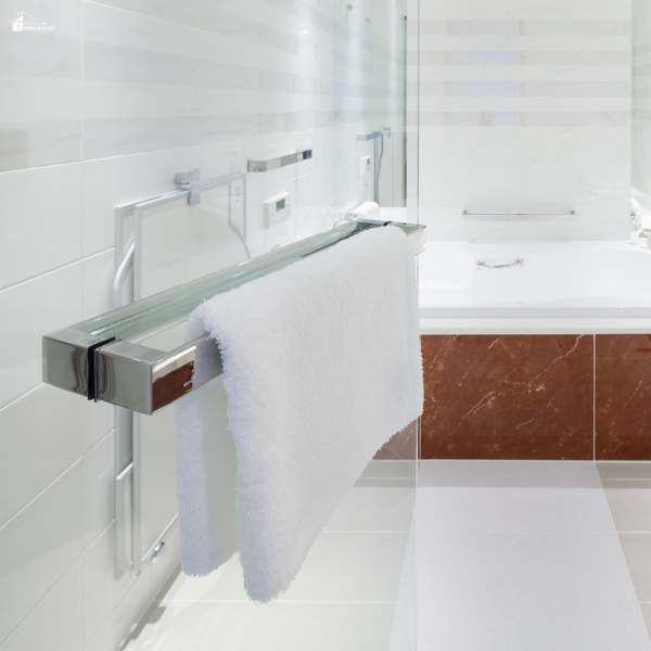 Wall-mounted towel radiator holding a white towel in a bright contemporary bathroom.