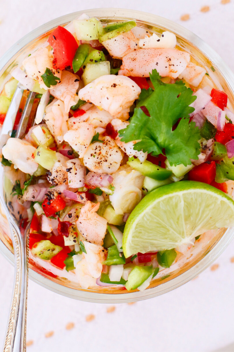Puerto Rican shrimp escabeche in a bowl with citrus marinade, fresh vegetables, lime wedge, and cilantro, a cold shrimp recipe with peppers, onion, and cucumber