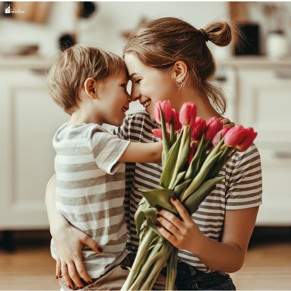 Mother hugging young child while holding pink tulips, representing affordable Mother’s Day gifts and meaningful family memories.