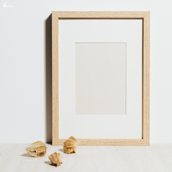 Simple wooden picture frame on a neutral surface showing a personalized photo gift idea for Mother’s Day on a budget.