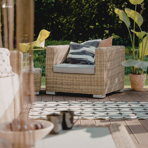 A cozy outdoor patio setup with wicker furniture and plants, showing a refreshed space ready for warmer weather.