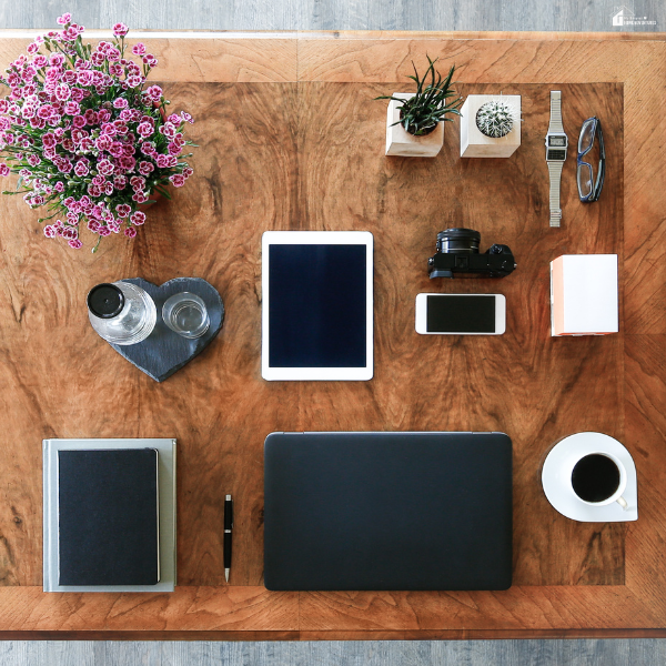 A neatly organized desk with a laptop, tablet, notebook, and small plants arranged to support focus in an ADHD-friendly workspace.
