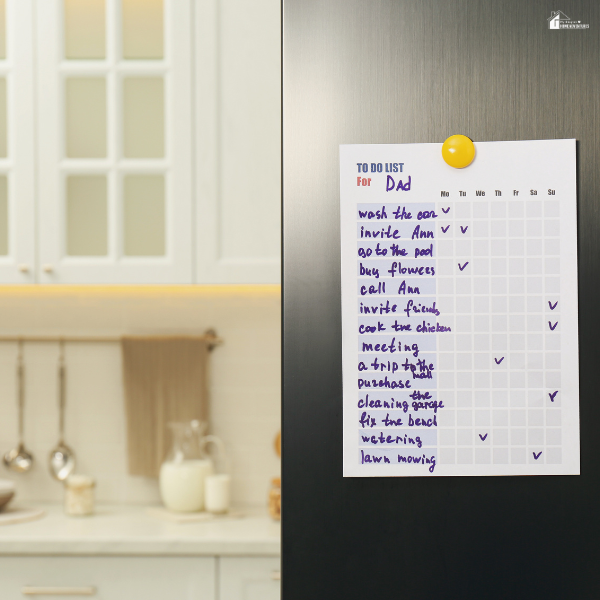 A handwritten weekly task list attached to a refrigerator, showing a simple system to manage daily routines in an ADHD-friendly home.