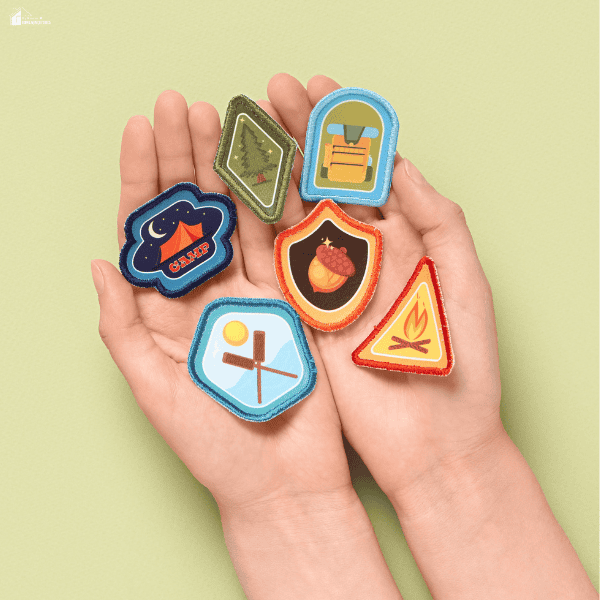 Hands holding colorful scout patches ready for organizing, sewing, and displaying in a collection.