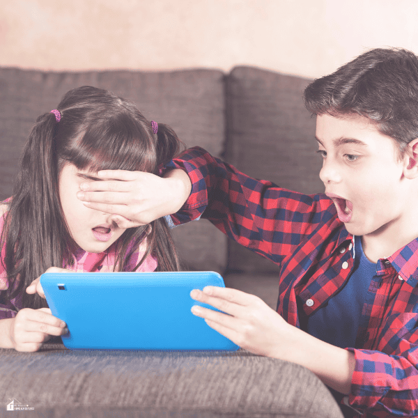 Children reacting to content on a tablet while sitting on a couch, highlighting the importance of parental guidance for online safety.