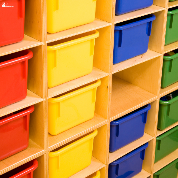 Colorful storage bins organized on wooden shelves showing a tidy and functional learning space setup for kids at home.