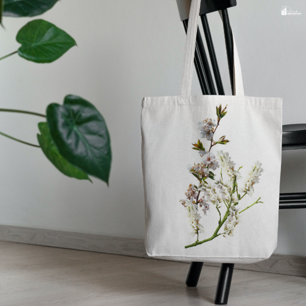Reusable tote bag hanging on a chair with a floral design, showing a simple and eco-friendly way to use bags at home.