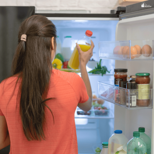 Woman organizing items inside a refrigerator, showing easy daily habits that help maintain order and reduce stress at home.