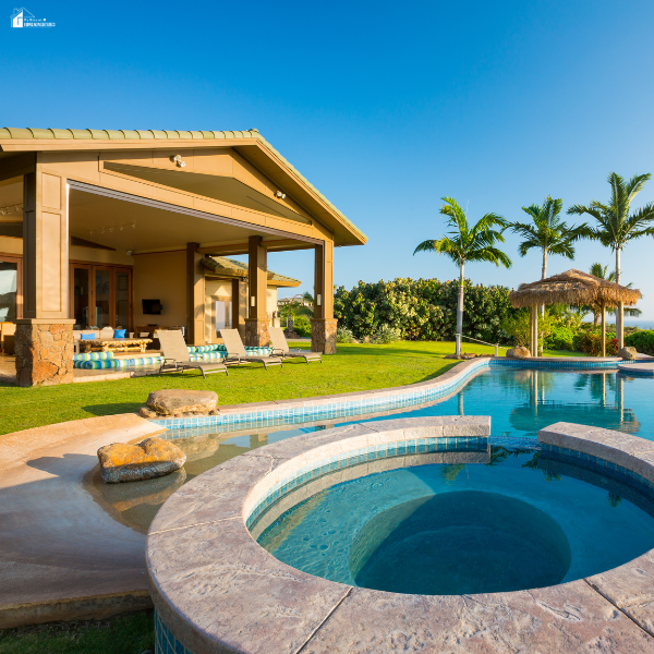 Luxury backyard pool and spa beside a home, highlighting the value of pool leak detection to protect water features and prevent damage.