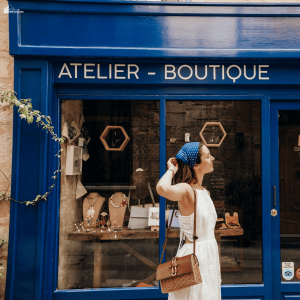 Woman standing outside a boutique storefront window, highlighting the importance of maintaining clear and intact shopfront glass for businesses.