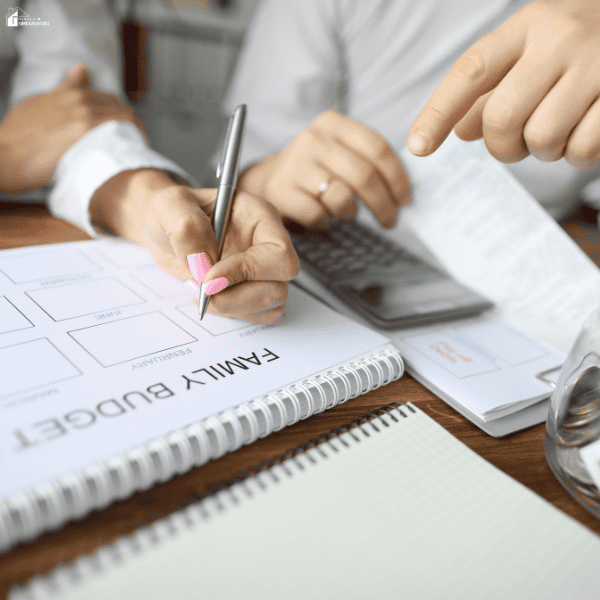 Family budgeting worksheet and calculator on a desk while planning expenses, savings, and financial goals at home.