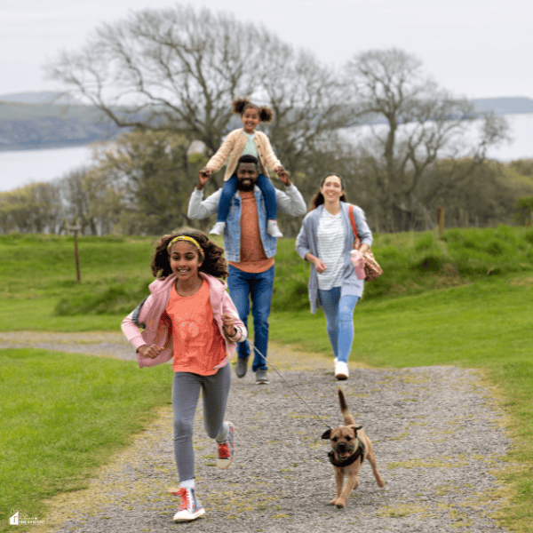 Parents and children enjoying outdoor family time with their dog while adjusting to life after moving into a new neighborhood.