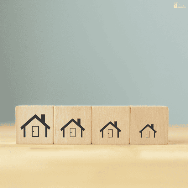 Wooden house blocks arranged from large to small to represent downsizing and simplified living for homeowners.