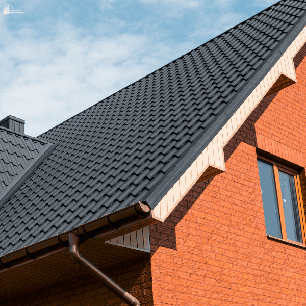 Modern dark shingle roof on a brick home showing durable roofing materials for long-lasting and budget-friendly home maintenance.