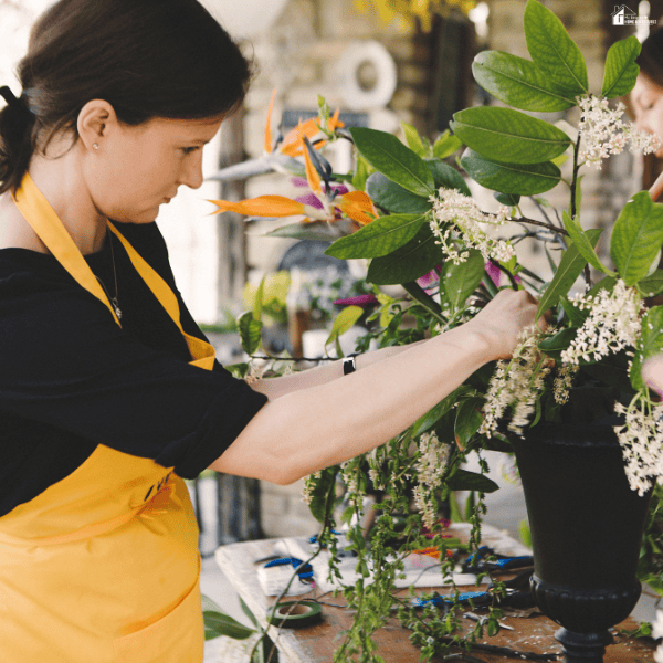 Floral designer arranging fresh greenery and blooms while using visual planning techniques to create a more cohesive wedding atmosphere.