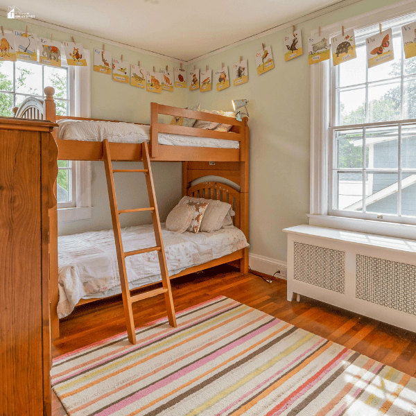Cozy children’s bedroom with wooden bunk beds and colorful decor prepared for kids after moving into a new home.