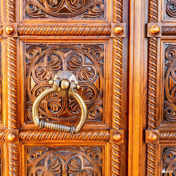 Ornate carved wooden cabinet doors with vintage brass hardware showing how decorative details add character to furniture.