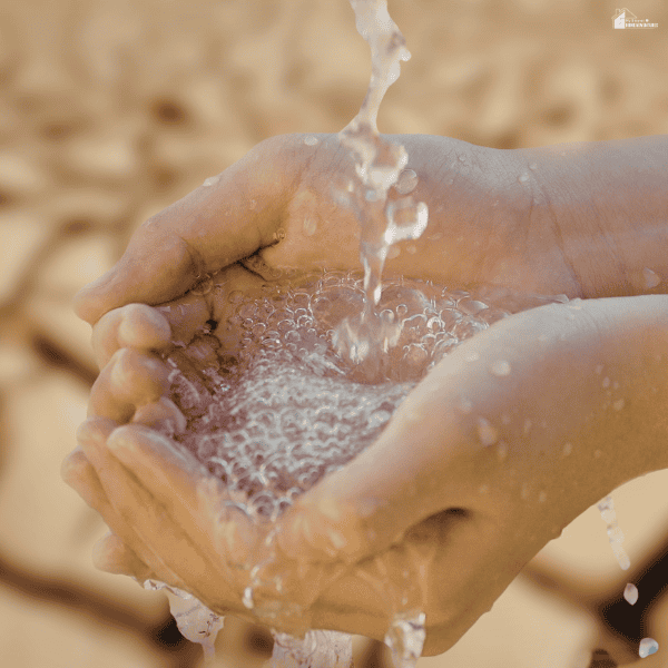 Hands catching clean running water to show concerns about strong chlorine smells in household water.