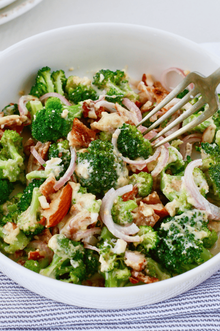 Creamy broccoli salad with bacon, red onion, almonds, and parmesan cheese served as an easy cold summer side dish.