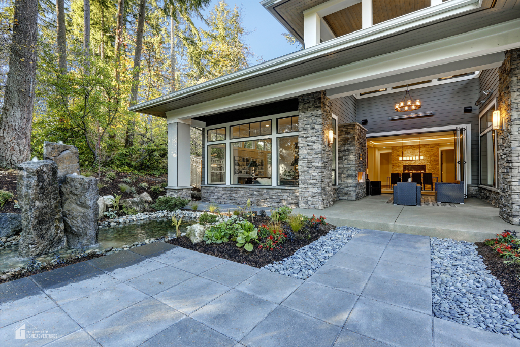 Modern home exterior with covered patio, stone accents, landscaped walkway, and outdoor living space creating a welcoming and elevated curb appeal design.