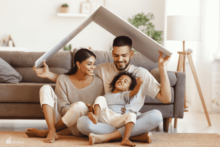 Family sitting together in cozy living room holding cushion overhead, representing a safe, comfortable, and family-ready home environment.