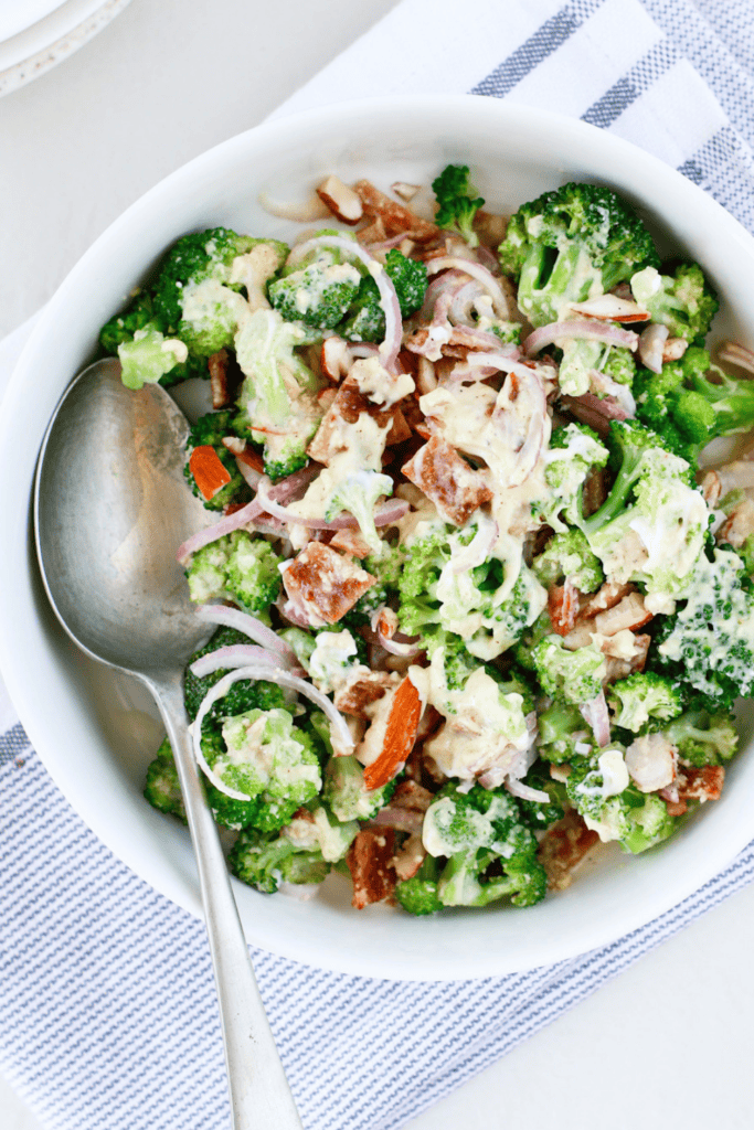 Easy broccoli salad with bacon, red onion, almonds, and creamy dressing served cold as a fresh summer side dish.