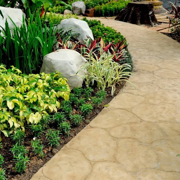 Landscaped garden walkway with plants and stone borders showing an outdoor living space designed for family comfort and everyday use.