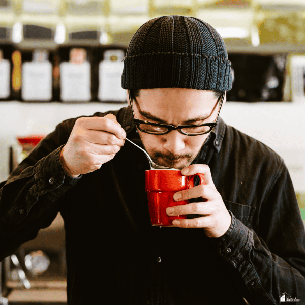 Coffee professional evaluating aroma and quality from a freshly brewed cup as part of specialty coffee tasting and quality control.