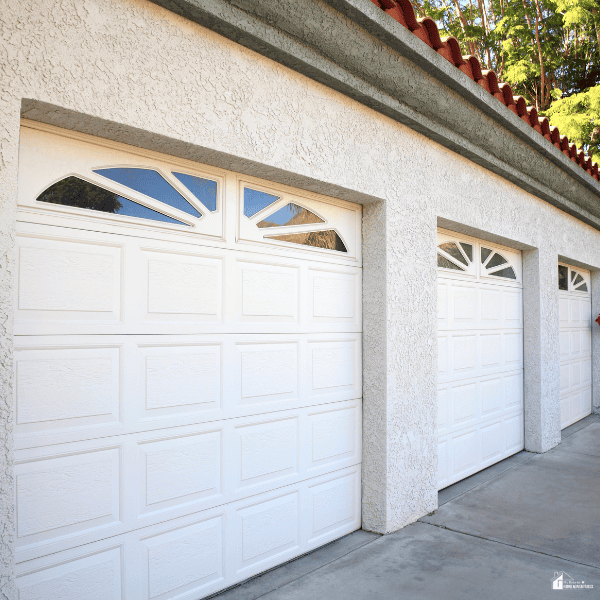 Residential garage with paneled overhead doors showcasing a durable and traditional design for long-term home value.