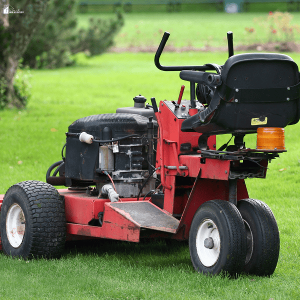 Commercial-grade riding mower positioned on a lawn, representing landscaping equipment rentals for large outdoor maintenance projects.
