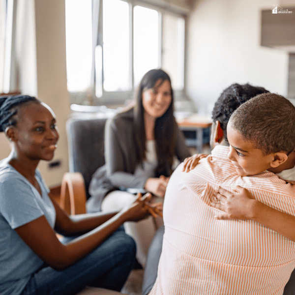 Child hugging a parent during a family support session, representing emotional well-being and consistent care routines.