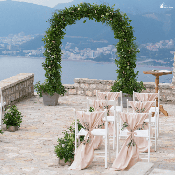 Scenic wedding venue overlooking the water with elegant floral décor and seating arranged for an intimate outdoor ceremony.