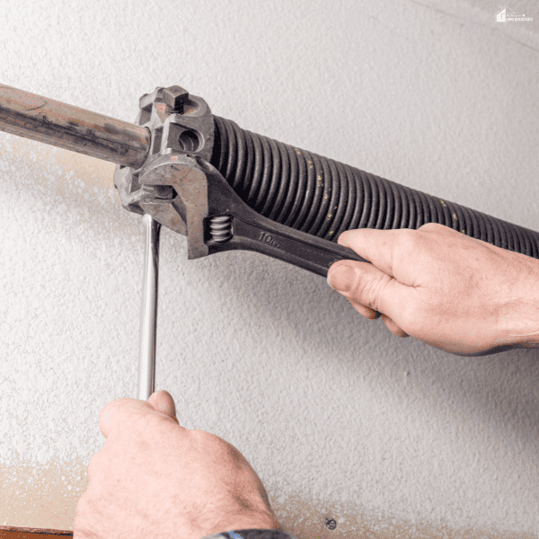 Technician adjusting a garage door torsion spring, demonstrating professional garage door repair and maintenance.