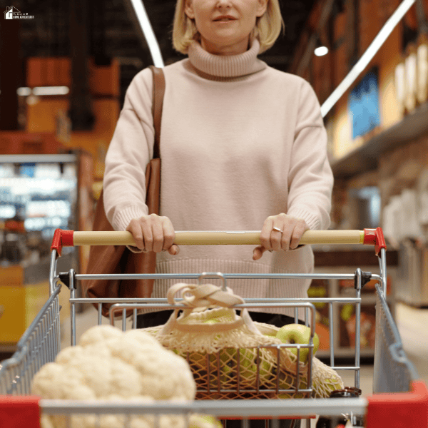 Person pushing a shopping cart filled with groceries, illustrating meal planning and food shopping for a campervan travel adventure.