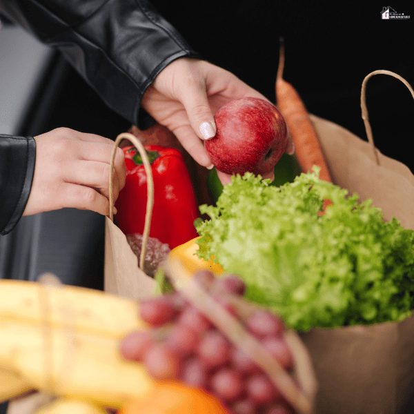 Fresh fruits and vegetables packed in reusable bags, representing smart grocery shopping and reducing food waste while traveling.