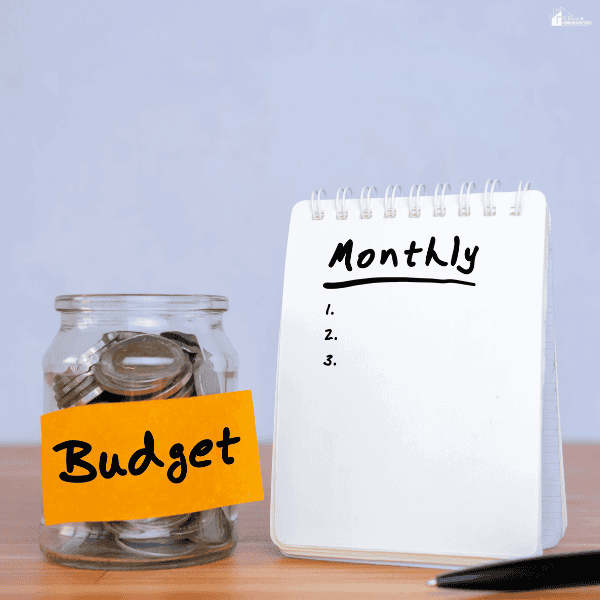 Savings jar and financial planning notebook used to organize spending goals and track progress during a monthly budgeting challenge.
