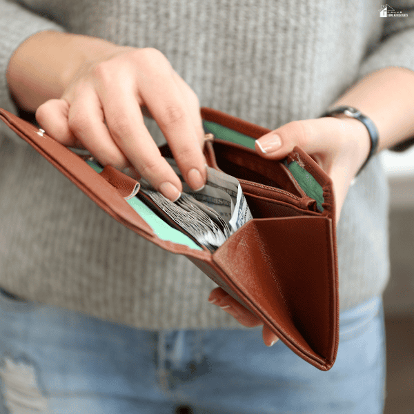 Individual checking cash in a wallet while evaluating available funds and planning monthly expenses.